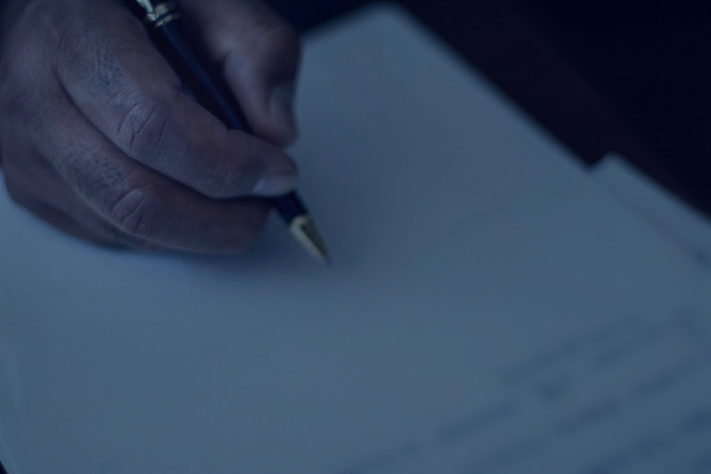 Manos redactando un documento sobre el escritorio
